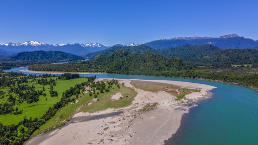 Delta del río con banco de arena y montañas nevadas