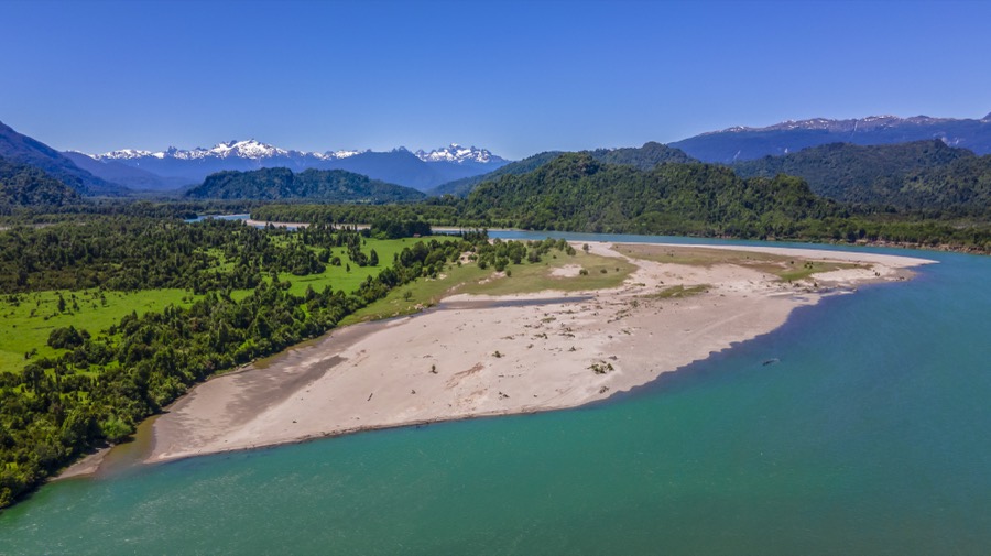 Playa de río con cordillera nevada al fondo
