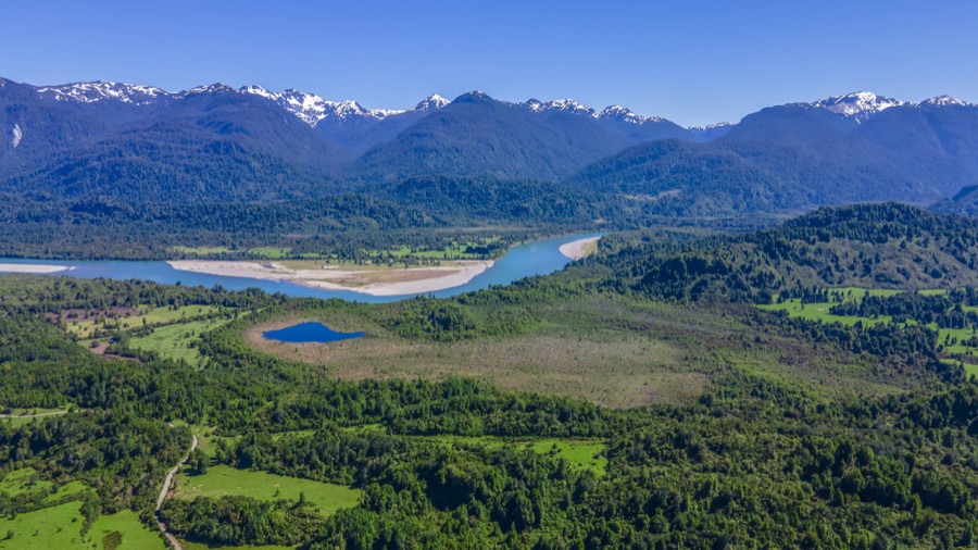 Isla en el río con cordillera nevada